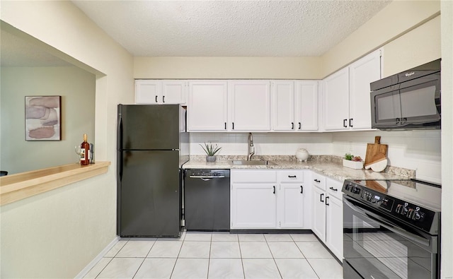 kitchen featuring black appliances, a textured ceiling, a sink, and white cabinetry