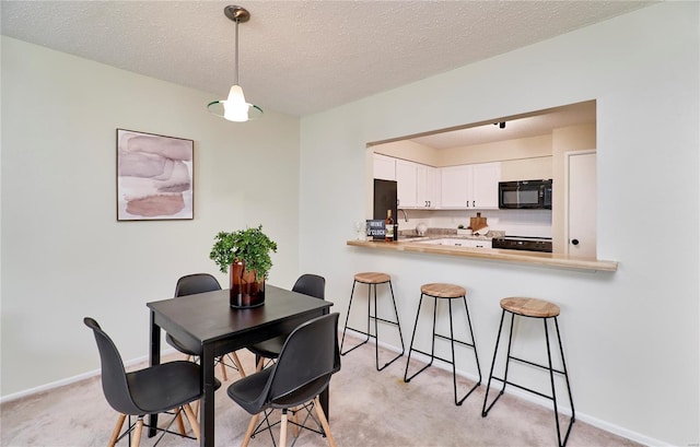 dining area featuring a textured ceiling, light carpet, and baseboards
