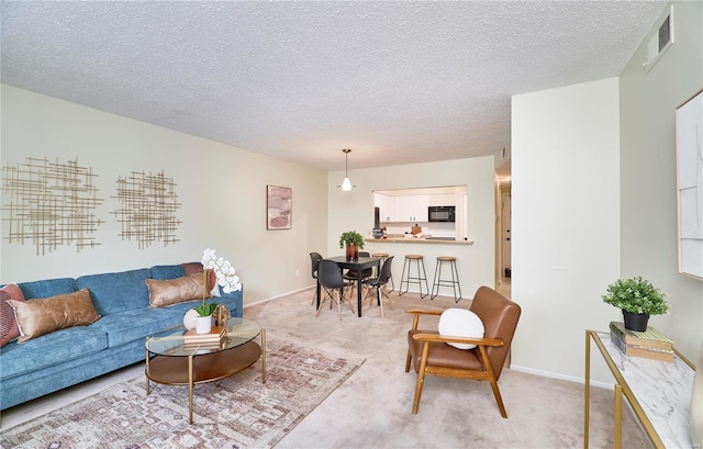 living area with a textured ceiling, visible vents, light colored carpet, and baseboards