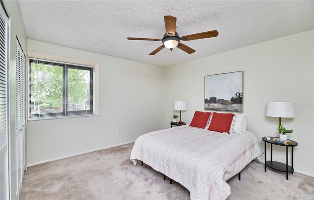 bedroom featuring a textured ceiling, ceiling fan, carpet, and baseboards