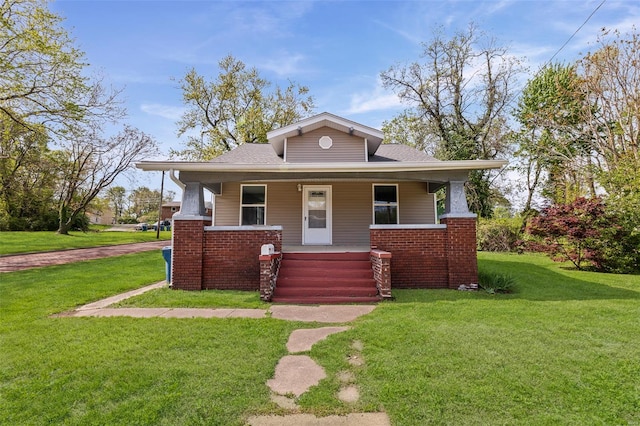 bungalow-style house featuring covered porch, a shingled roof, and a front lawn