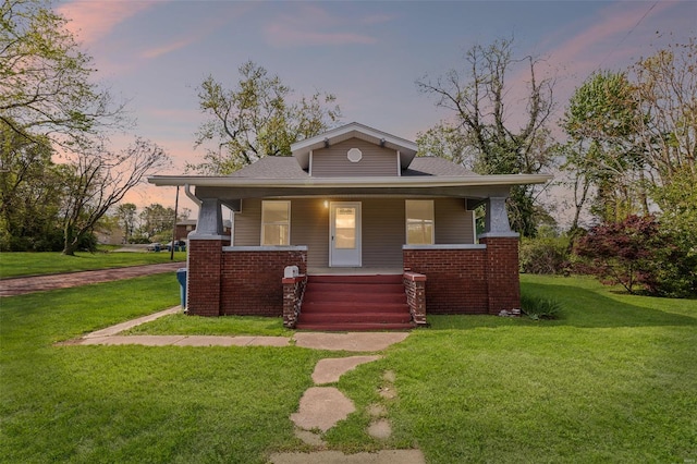 bungalow-style home featuring covered porch and a front yard