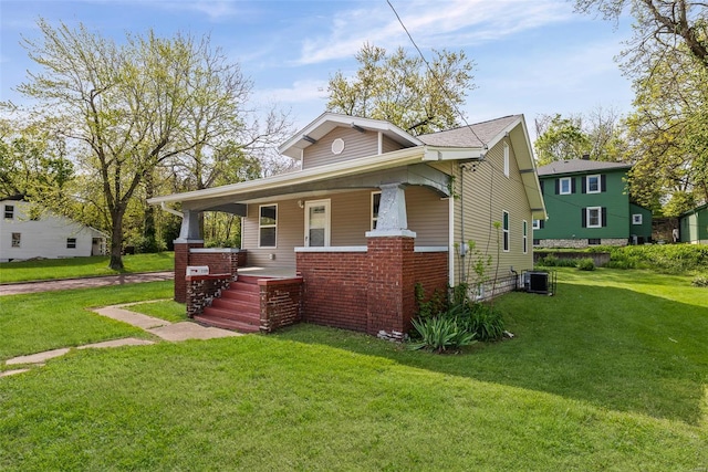 bungalow with central AC, a porch, and a front lawn
