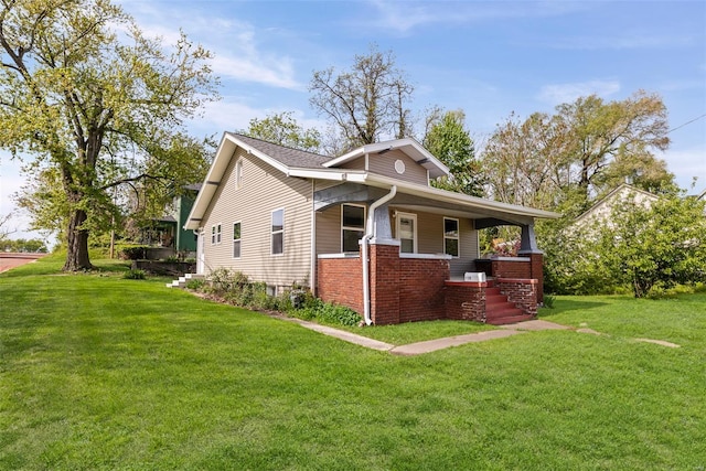 exterior space with covered porch, brick siding, and a yard