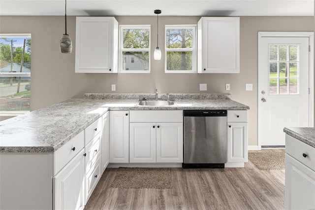 kitchen with white cabinetry, light wood-type flooring, stainless steel dishwasher, and a sink
