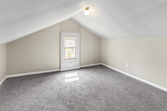 additional living space with lofted ceiling, carpet flooring, and baseboards