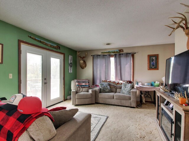 living room featuring french doors, a textured ceiling, and light colored carpet