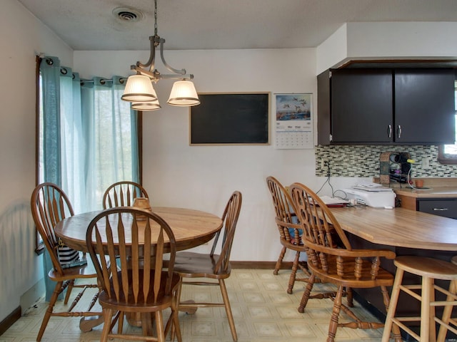 dining room with visible vents, baseboards, and light floors