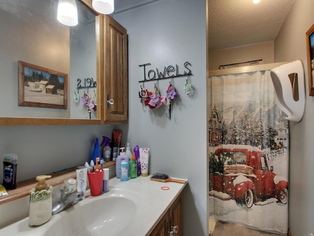 bathroom featuring vanity, a textured ceiling, and curtained shower