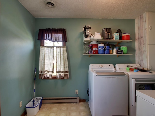 clothes washing area featuring tile patterned floors, a baseboard heating unit, laundry area, washing machine and dryer, and visible vents