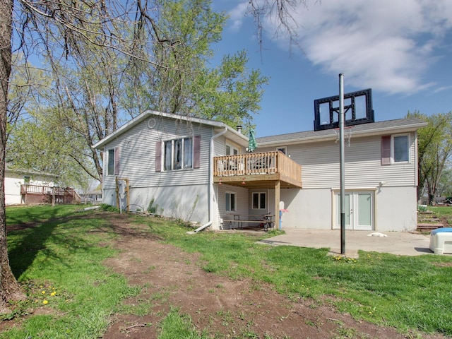 back of property featuring a wooden deck, a yard, and a patio