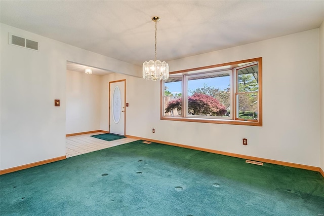 carpeted empty room featuring a notable chandelier, visible vents, and baseboards
