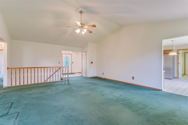 spare room featuring baseboards, a ceiling fan, vaulted ceiling, and light carpet