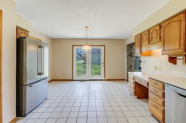 kitchen with baseboards, light countertops, hanging light fixtures, and stainless steel appliances
