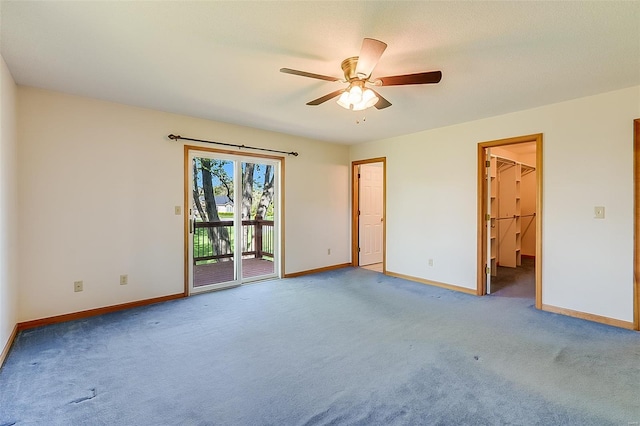 carpeted empty room with a ceiling fan and baseboards