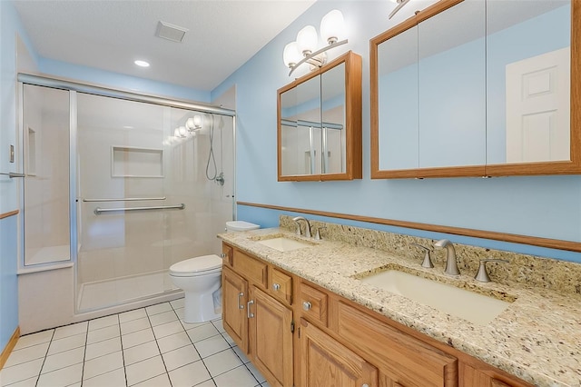 bathroom with toilet, tile patterned floors, a sink, and a shower with shower door