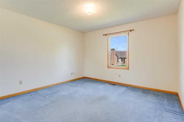 carpeted empty room featuring visible vents and baseboards