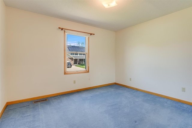 carpeted spare room with baseboards and visible vents