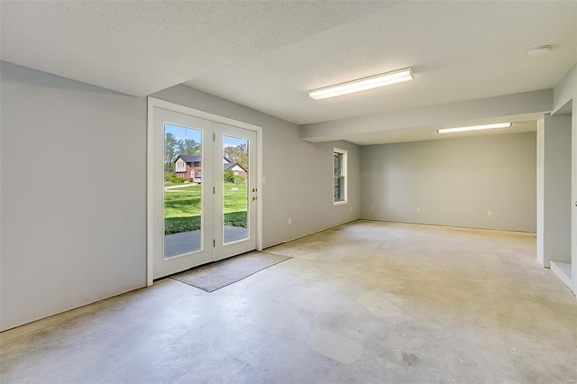 empty room with a textured ceiling and concrete floors