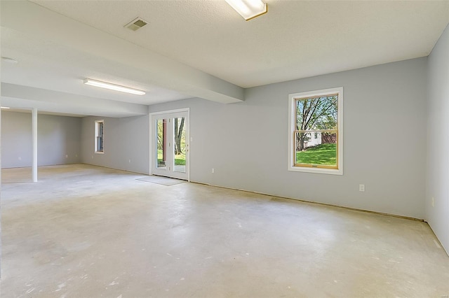 spare room with visible vents, concrete floors, and plenty of natural light