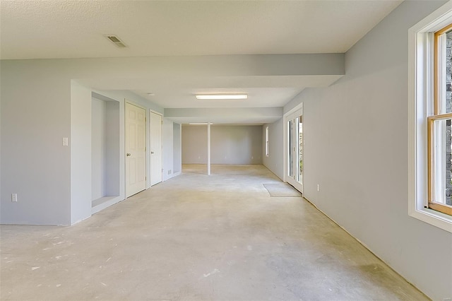 interior space featuring a healthy amount of sunlight, concrete floors, and visible vents