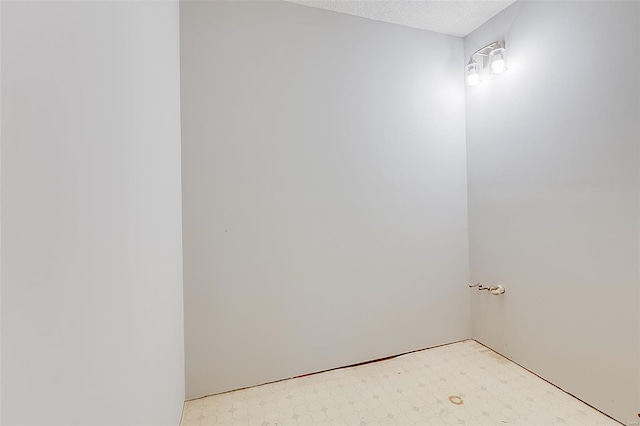 bathroom with a textured ceiling and tile patterned floors