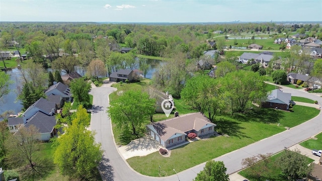 aerial view featuring a water view, a view of trees, and a residential view