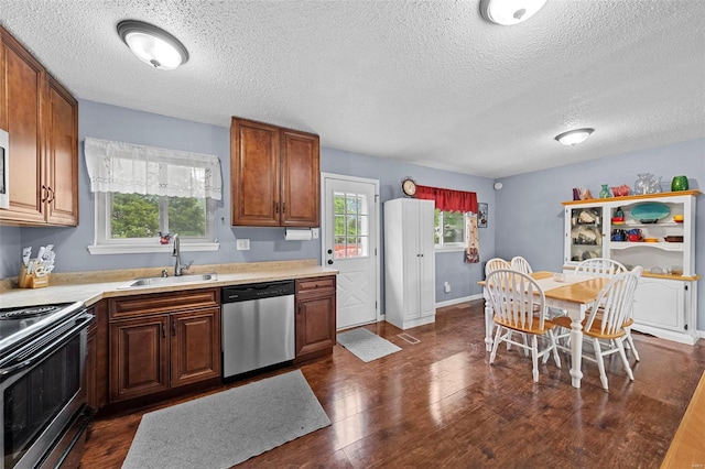 kitchen featuring a sink, stainless steel dishwasher, range with electric cooktop, and a textured ceiling