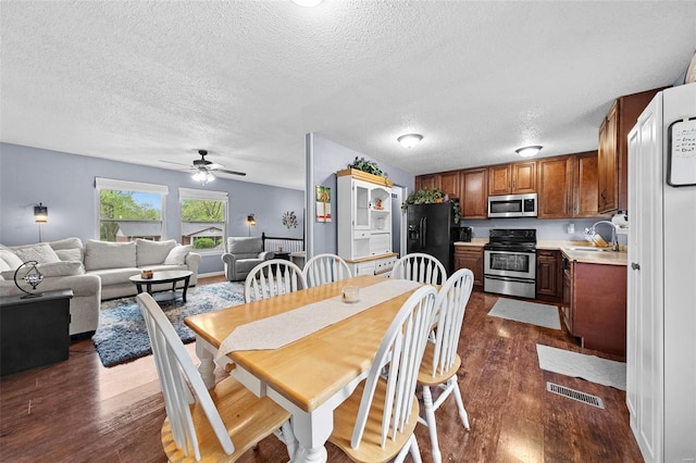 dining room with visible vents, a textured ceiling, dark wood-style flooring, and ceiling fan