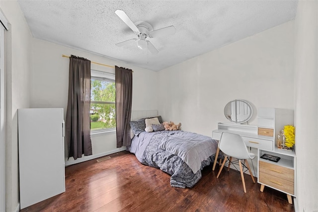 bedroom featuring visible vents, a ceiling fan, a textured ceiling, and wood finished floors