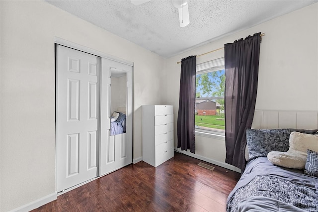 bedroom featuring visible vents, baseboards, a textured ceiling, and wood finished floors