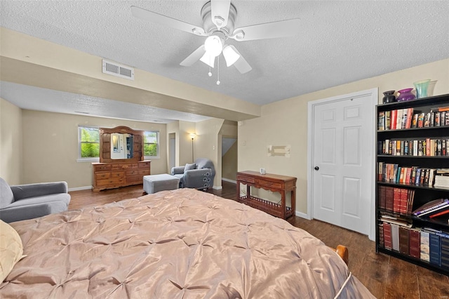 bedroom featuring a textured ceiling, baseboards, wood finished floors, and visible vents
