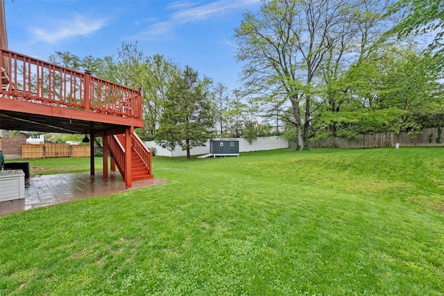 view of yard featuring an outdoor structure, a deck, a patio, a fenced backyard, and stairs