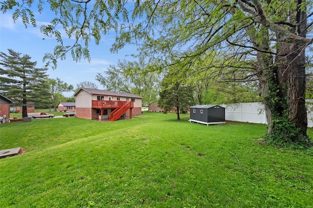 view of yard featuring fence, stairs, a wooden deck, a shed, and an outdoor structure