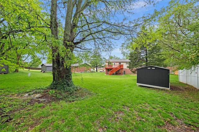 view of yard with a wooden deck, a storage unit, an outdoor structure, and stairs