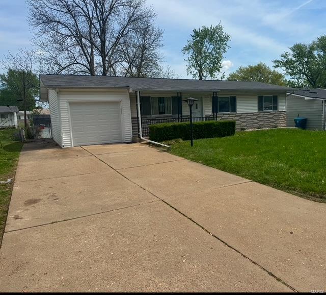 single story home with covered porch, an attached garage, driveway, and a front lawn