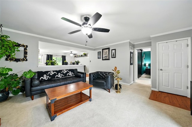living room with crown molding, light carpet, baseboards, and ceiling fan