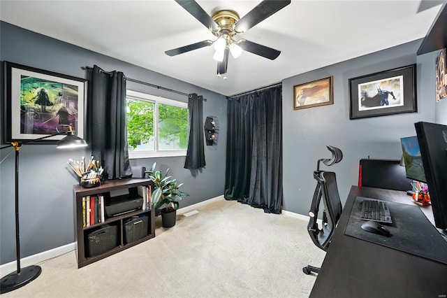 carpeted home office featuring baseboards and a ceiling fan