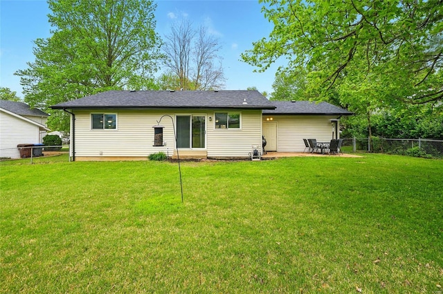 rear view of house featuring a patio, fence, and a lawn
