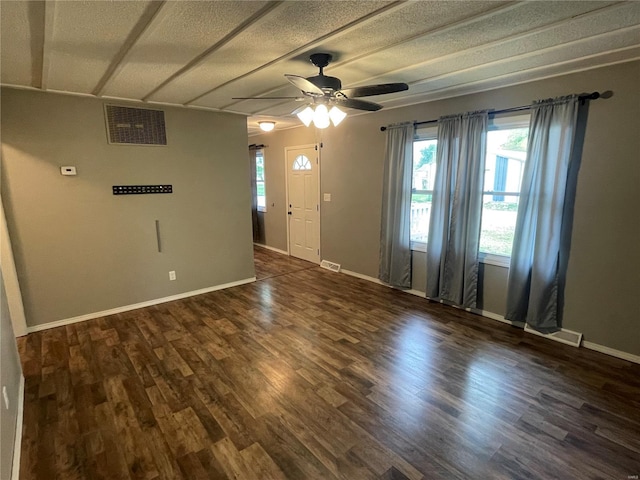 spare room with visible vents, ceiling fan, a textured ceiling, and dark wood-style flooring