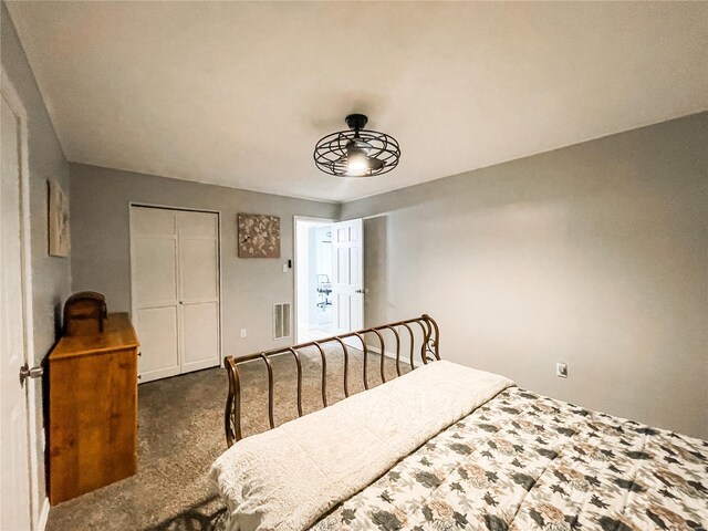 carpeted bedroom with visible vents and a closet