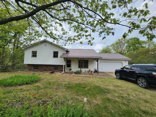 split level home featuring metal roof, a front yard, a garage, and a porch