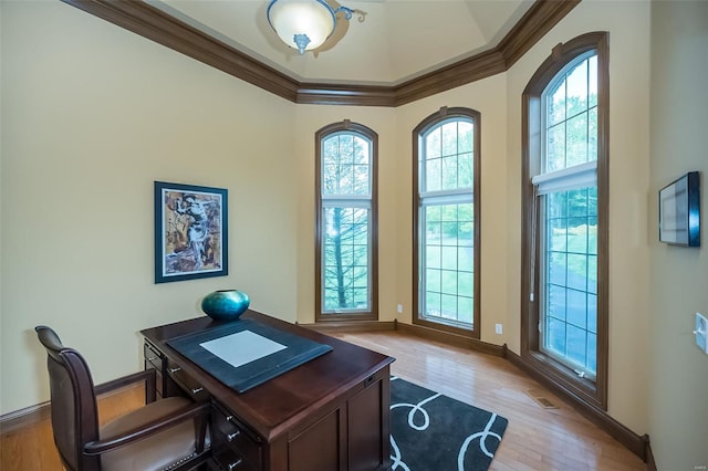 office area with baseboards, visible vents, ornamental molding, and wood finished floors