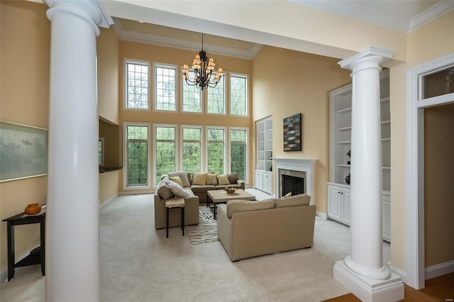 living area with a towering ceiling, baseboards, ornamental molding, and decorative columns
