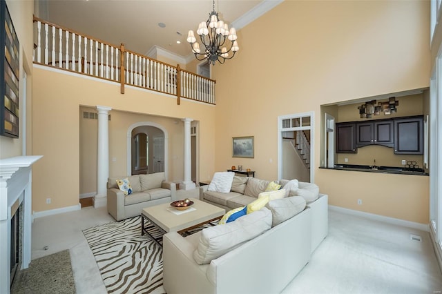 living room with stairs, decorative columns, light carpet, baseboards, and a high ceiling
