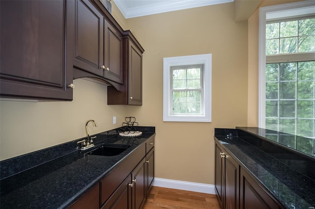 kitchen with a wealth of natural light, light wood-style floors, baseboards, and a sink