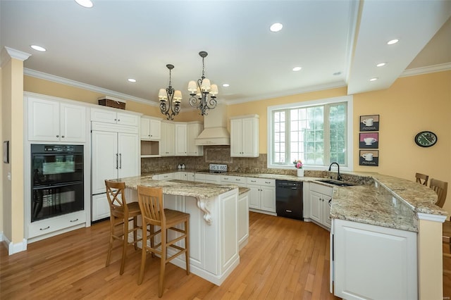 kitchen with a chandelier, black appliances, ornamental molding, and a kitchen breakfast bar