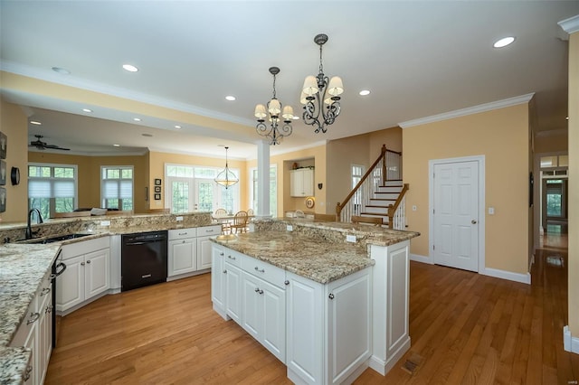 kitchen with ornamental molding, black dishwasher, light wood-style flooring, and a sink