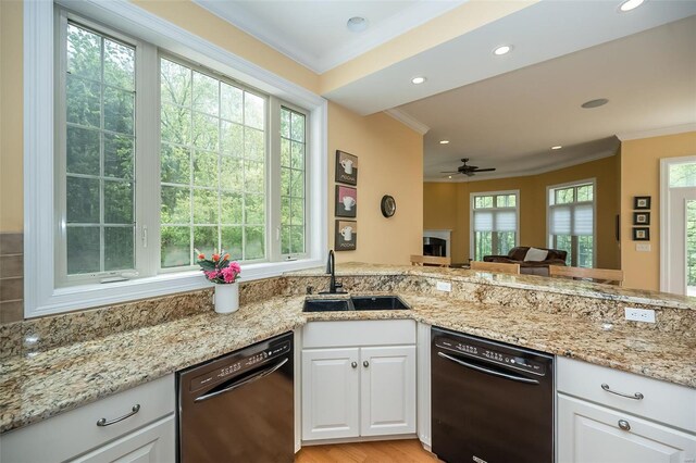 kitchen with black dishwasher, crown molding, and a sink