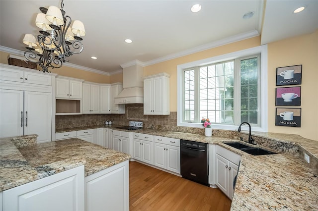 kitchen with crown molding, a sink, black appliances, an inviting chandelier, and light wood finished floors